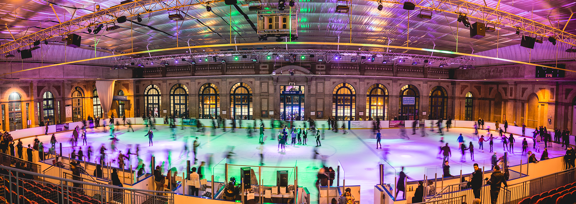 People ice skating, illuminated by colourful lights