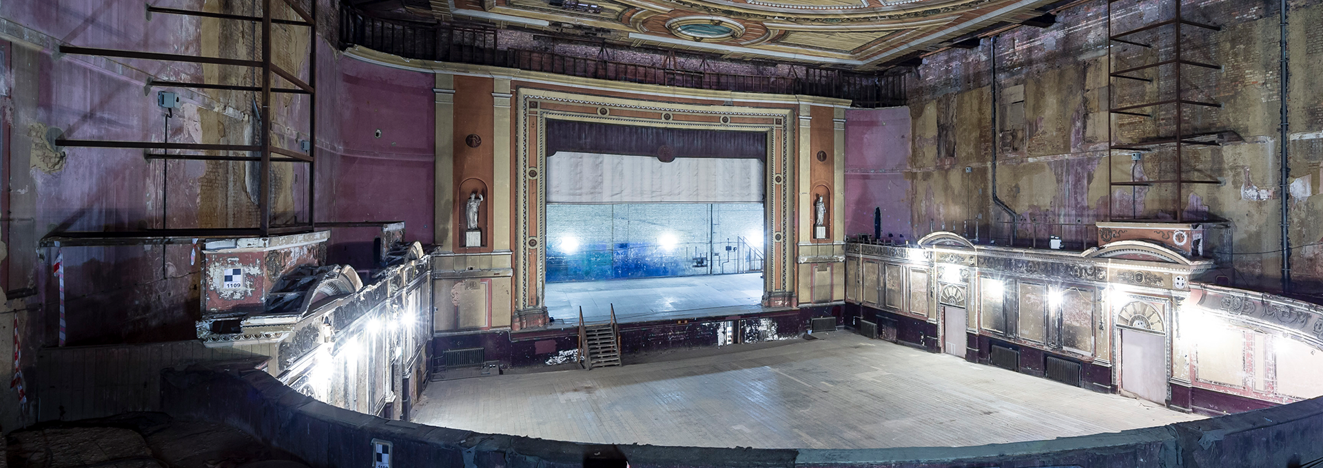 Restoration of a worn auditorium with a stage.