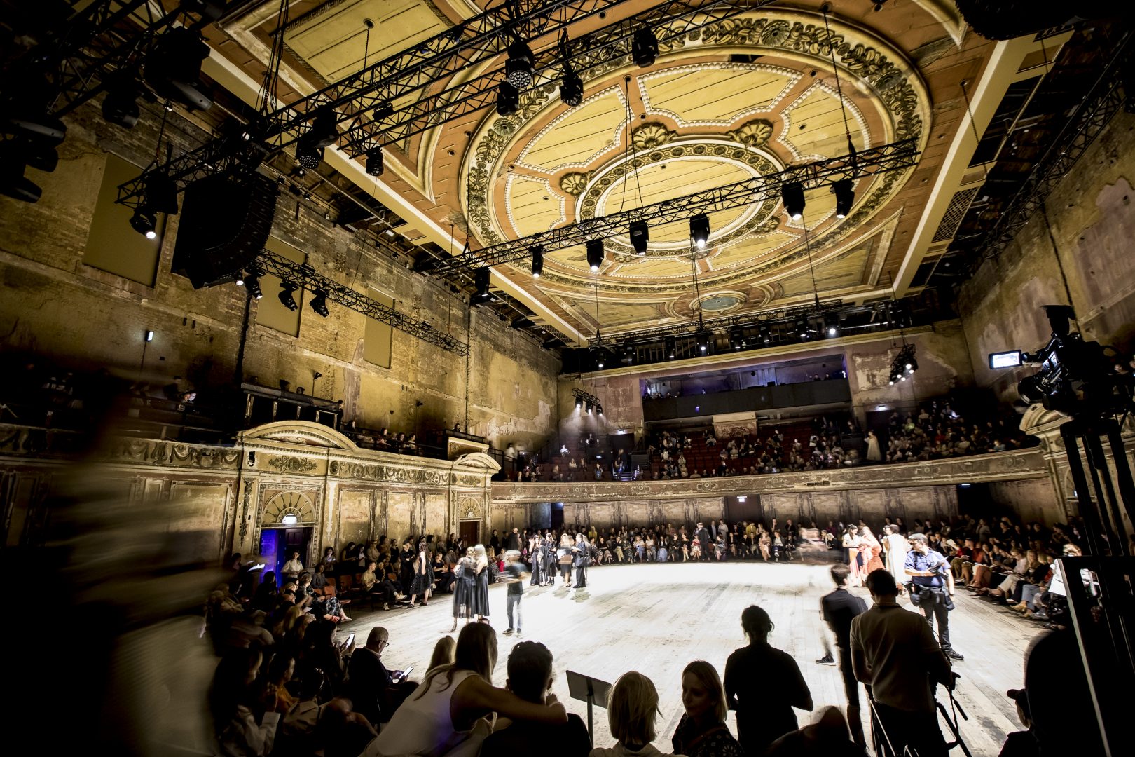 People stood in a circle in the auditorium at Alexandra Palace for London Fashion Week.