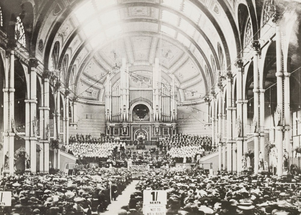 A choir stands around the Grand Willis Organ during a concert in the Great Hall at Alexandra Palace
