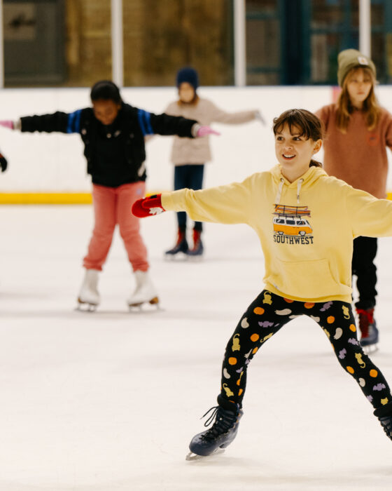 A child skating on an Ally pally Ice Rink, smiling.